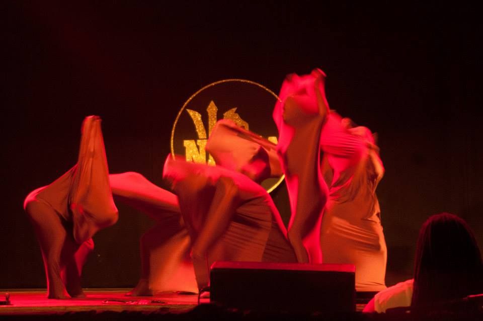 Dancers wrapped in fabric under red light